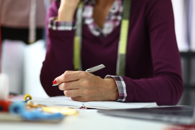 Femme avec manucure rouge avec stylo.