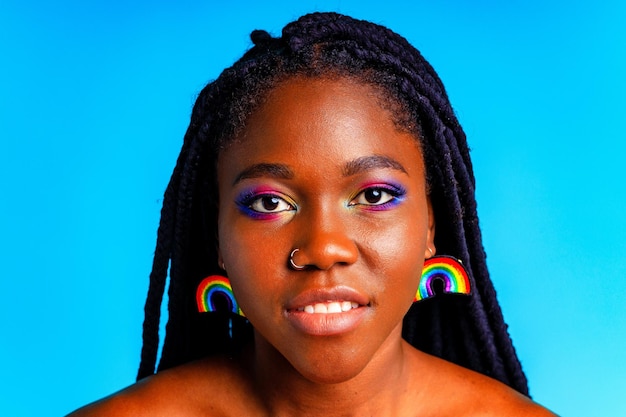 Femme avec maquillage arc-en-ciel et longs cils en studio bleu baclground