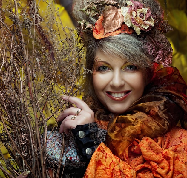 femme avec un maquillage brillant avec des branches sèches