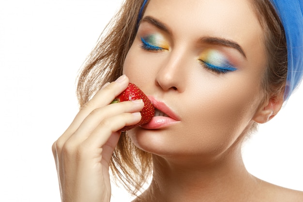 Femme, maquillage coloré, mange, fraise