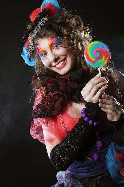 Femme avec un maquillage créatif dans un style poupée avec des bonbons
