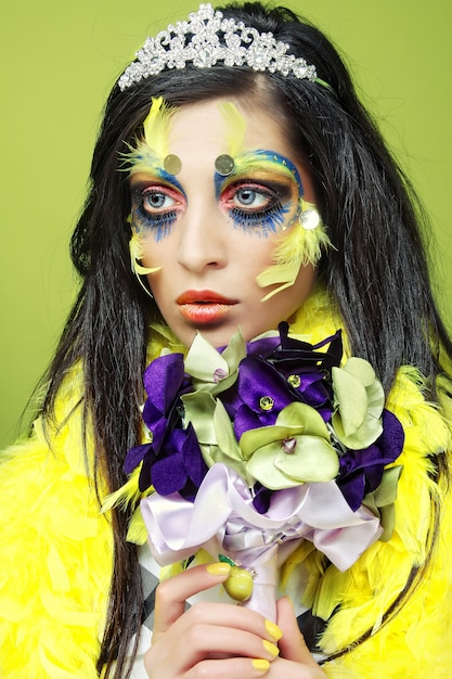 Photo femme avec maquillage créatif tenant un bouquet de bijoux