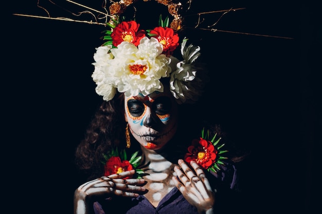 Femme avec le maquillage d'halloween crâne mexicain sur le visage. Jour des morts aka Dia de los Muertos et concept d'halloween.