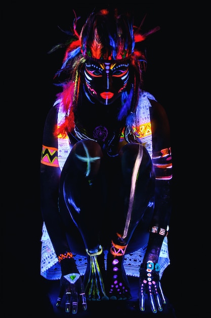 Femme avec un maquillage néon en lumière ultraviolette