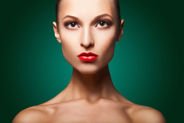 Femme avec maquillage rouge et manucure sur vert