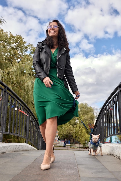 Femme marchant avec un chat en laisse à l'extérieur