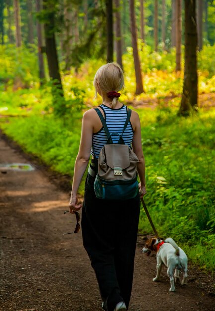 Femme marchant avec un chien dans une forêt en Pologne