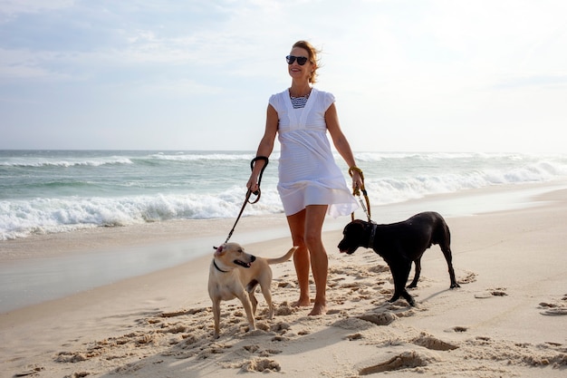 Femme marchant avec les chiens sur la plage, Barra da Tijuca Rio de Janeiro