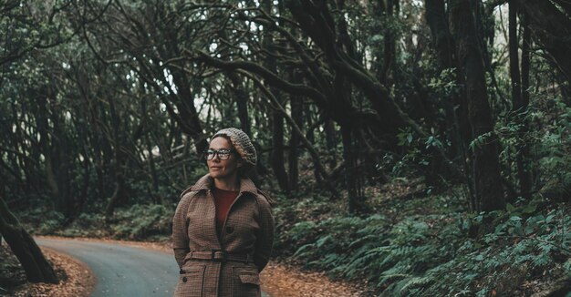 Une femme marchant dans les bois de la forêt verte sur la route avec des arbres autour de profiter de la nature et de l'environnement du parc national Activité de loisirs de plein air d'hiver avec des touristes de sexe féminin profitant d'un endroit pittoresque