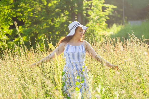 Femme marchant dans un champ en journée ensoleillée d'été