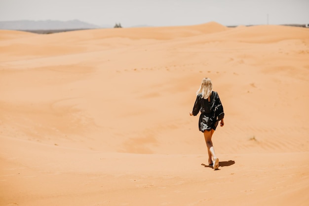 Une femme marchant dans le désert par une journée ensoleillée