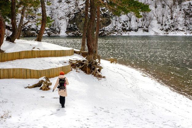 femme marchant dans la neige au bord du lac