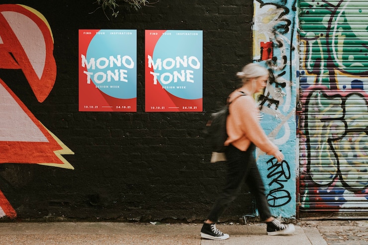 Photo femme marchant devant la peinture murale et les affiches d'art de rue