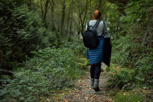 femme marchant le long d'un chemin forestier