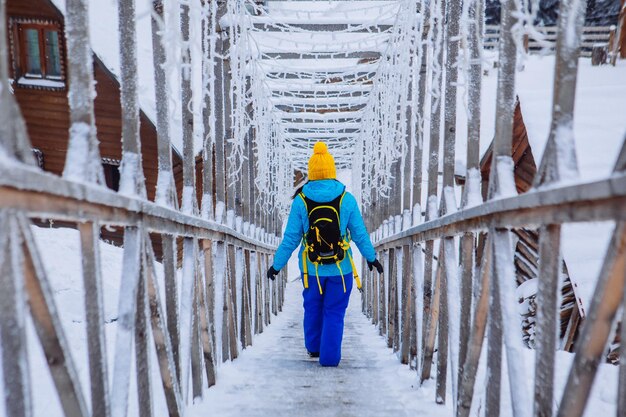 Femme marchant par des escaliers enneigés glacés à la station de montagne d'hiver Mountains Resort