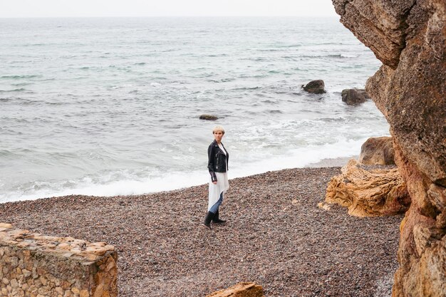 Femme marchant près de la falaise près de la mer en automne ou en été