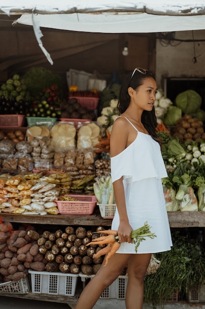 Femme sur le marché achetant des légumes