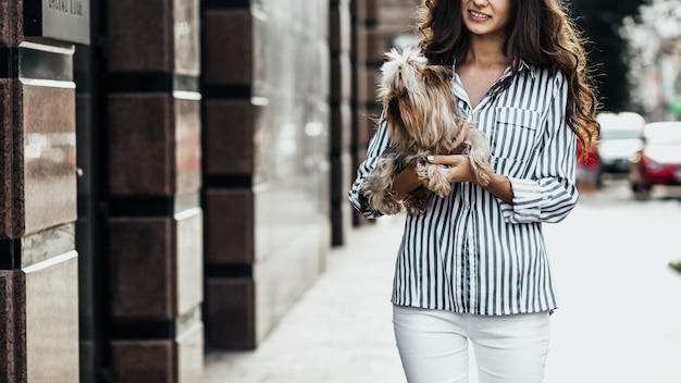 femme marche avec un chien dans la rue de la ville.