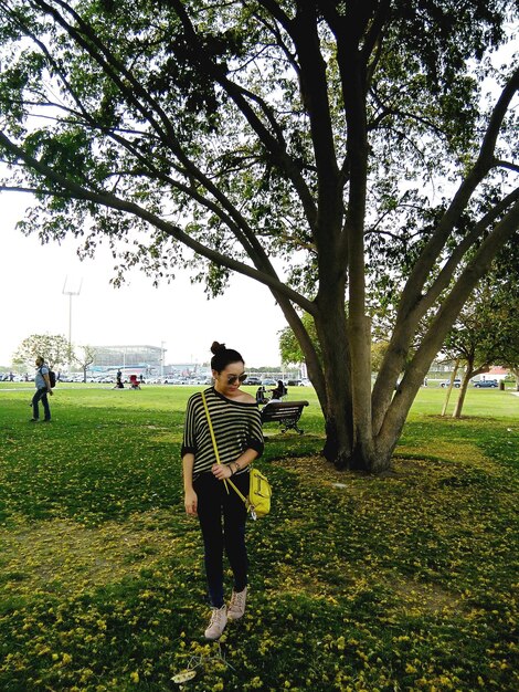 Photo une femme marche contre un arbre dans le parc.