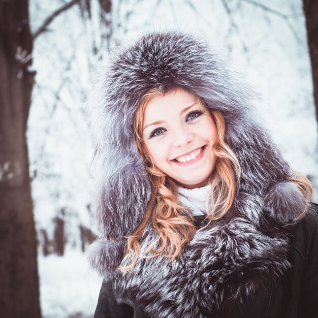 La femme marche dans l'allée du parc en hiver