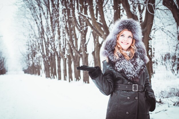 La femme marche dans l'allée du parc en hiver