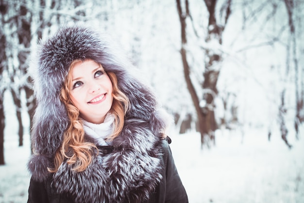 La femme marche dans l'allée du parc en hiver