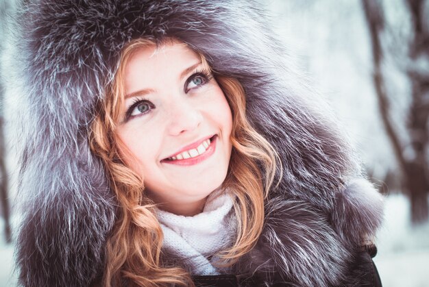 La femme marche dans l'allée du parc en hiver