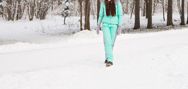 Femme marche dans le paysage enneigé d'hiver.