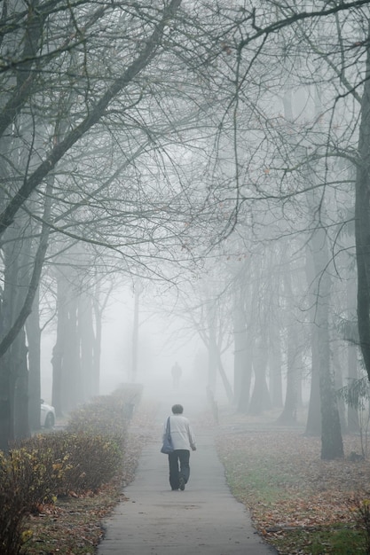 Une femme marche dans une ruelle brumeuse à Obninsk.