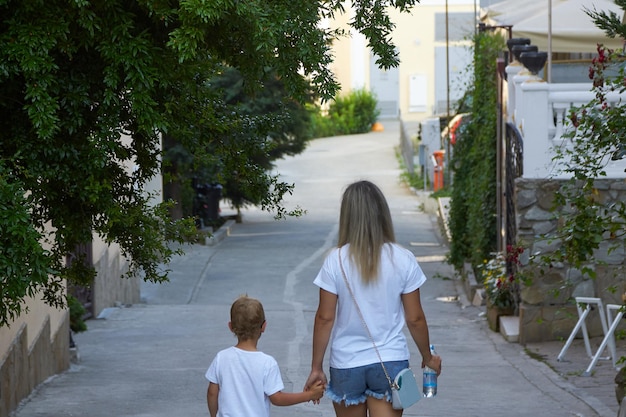 Une femme marche avec un enfant portant des T-shirts blancs identiques