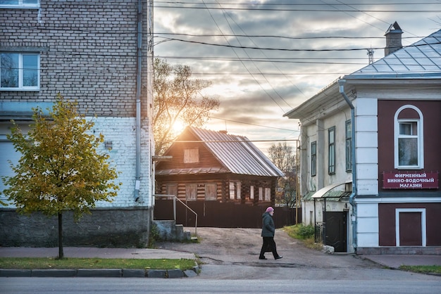 Une femme marche entre les maisons neuves et anciennes à Ouglitch