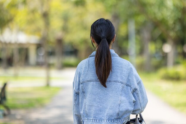 Une femme marche le long du parc vert.