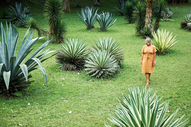 Femme marche sur paysage champ vert parmi les agaves