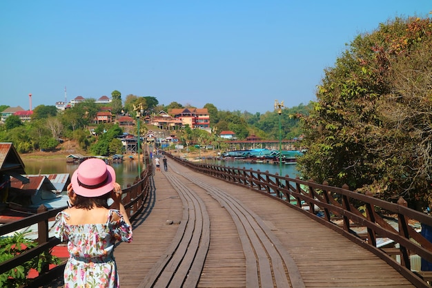 Une femme marche sur le pont Mon, le plus long pont en bois de Thaïlande, dans le district de Sangkhlaburi, à Kanchanaburi, en Thaïlande.