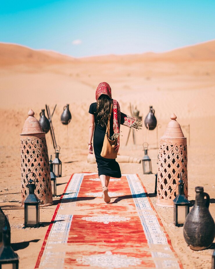 Photo une femme marche sur un tapis dans le désert