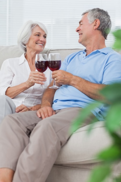 Femme et mari tinter leurs verres de vin rouge