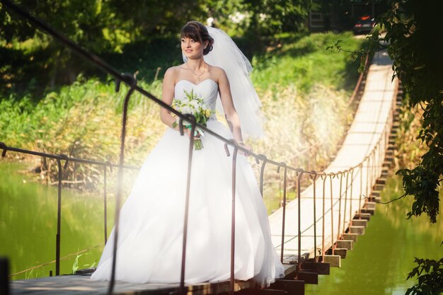 Femme mariée debout sur le pont au-dessus de la rivière