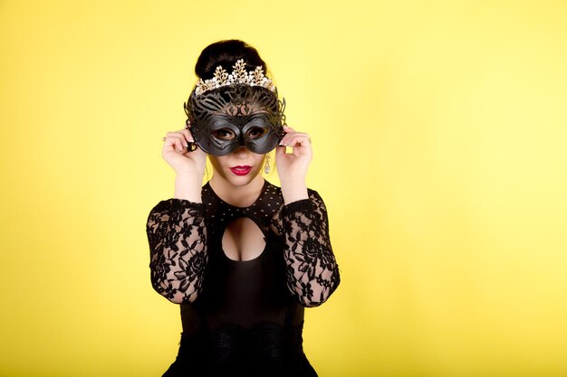 Photo femme avec masque de carnaval sur jaune