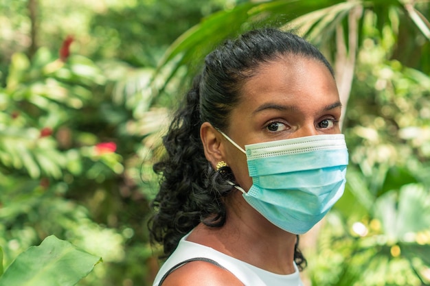 Femme avec masque de protection marchant dans la jungle. Concept de vacances et de tourisme