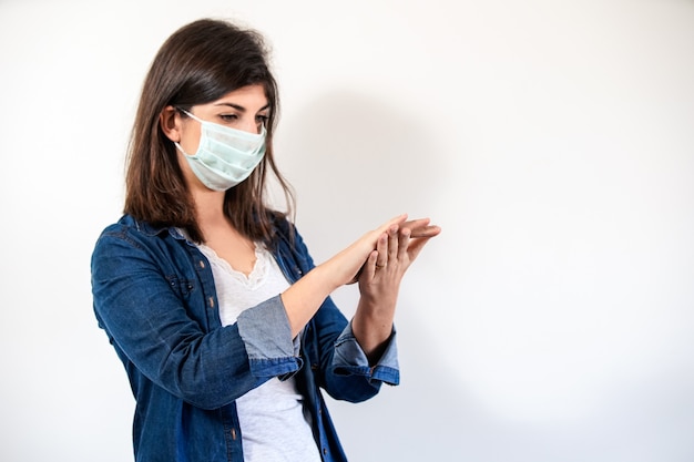 Photo femme avec un masque de protection médicale, nettoyer ses mains.