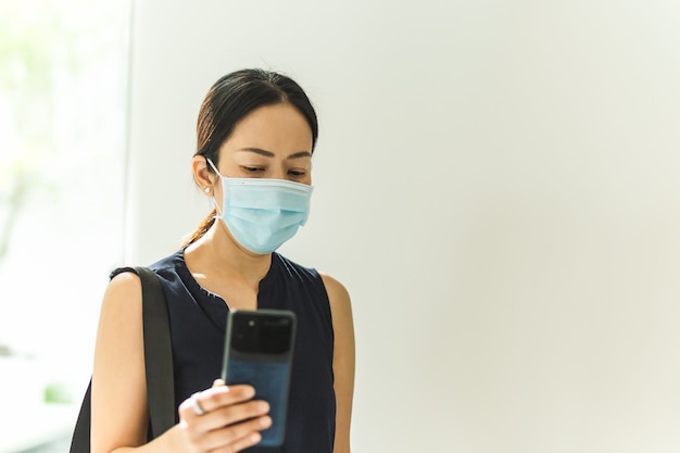 Femme avec masque de protection passe un appel vidéo