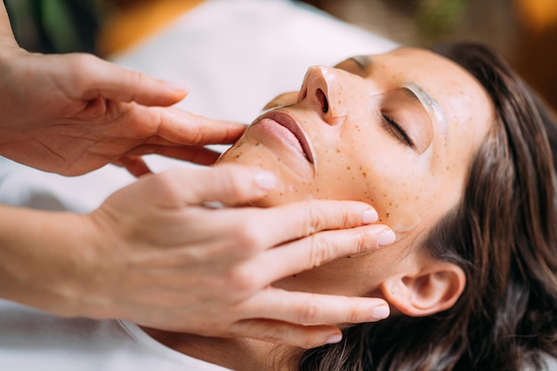 Femme avec un masque de soin de la peau dans un salon de beauté