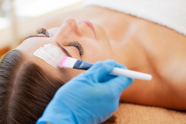 Femme en masque sur le visage dans un salon de beauté spa