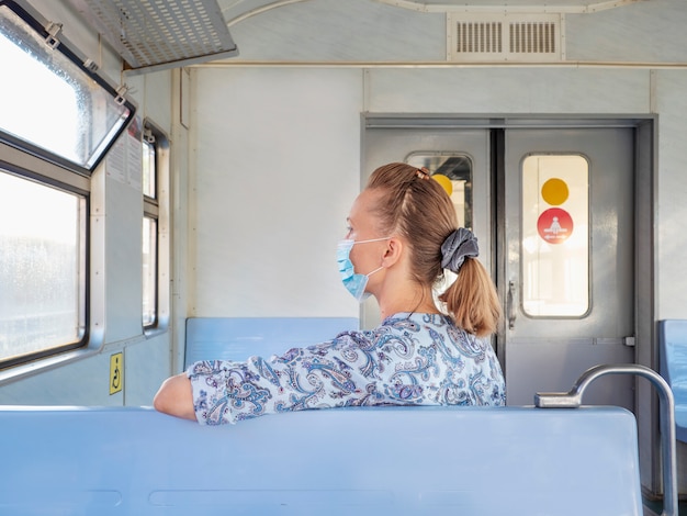 Photo femme masquée dans un train. sécurité dans un lieu public pendant l'épidémie de covid-19