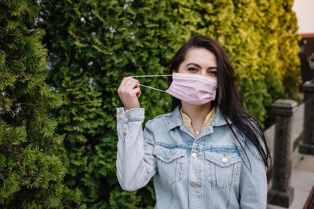 Une femme masquée se promène dans le parc pendant la quarantaine du coronavirus et des allergies printanières