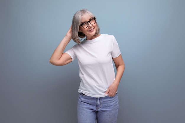 Une femme mature de l'âge de la retraite est en ménopause dans un débardeur blanc sur un fond de studio