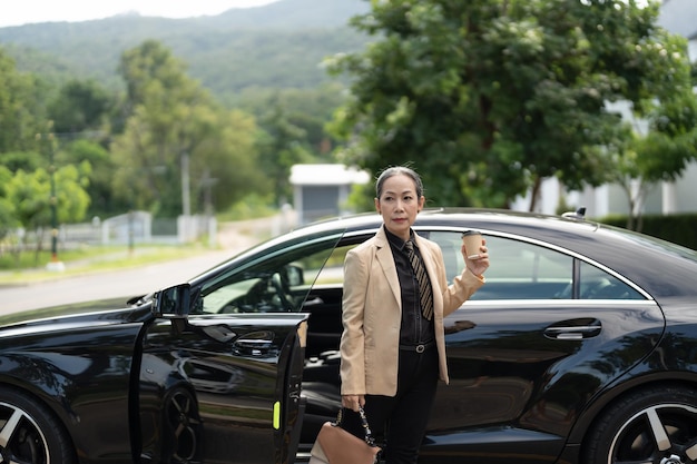 Femme mature asiatique débarquant de la voiture de luxe