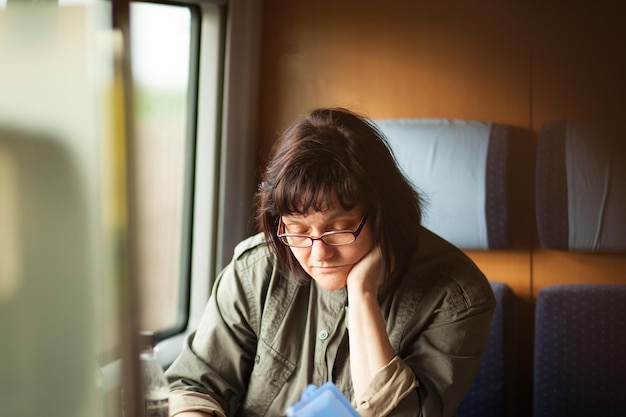 Une femme mature assise dans le train.