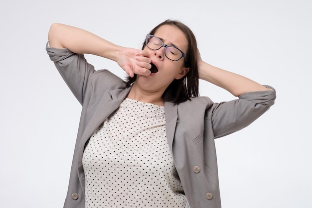 Femme mature bâillant et s'étirant après une dure journée de travail