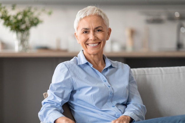 Femme mature caucasienne joyeuse et confiante avec des cheveux courts posant à l'intérieur